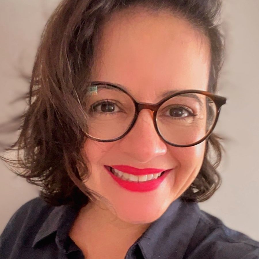 Flávia Cavalcanti sorrindo, vestindo camisa azul-marinho